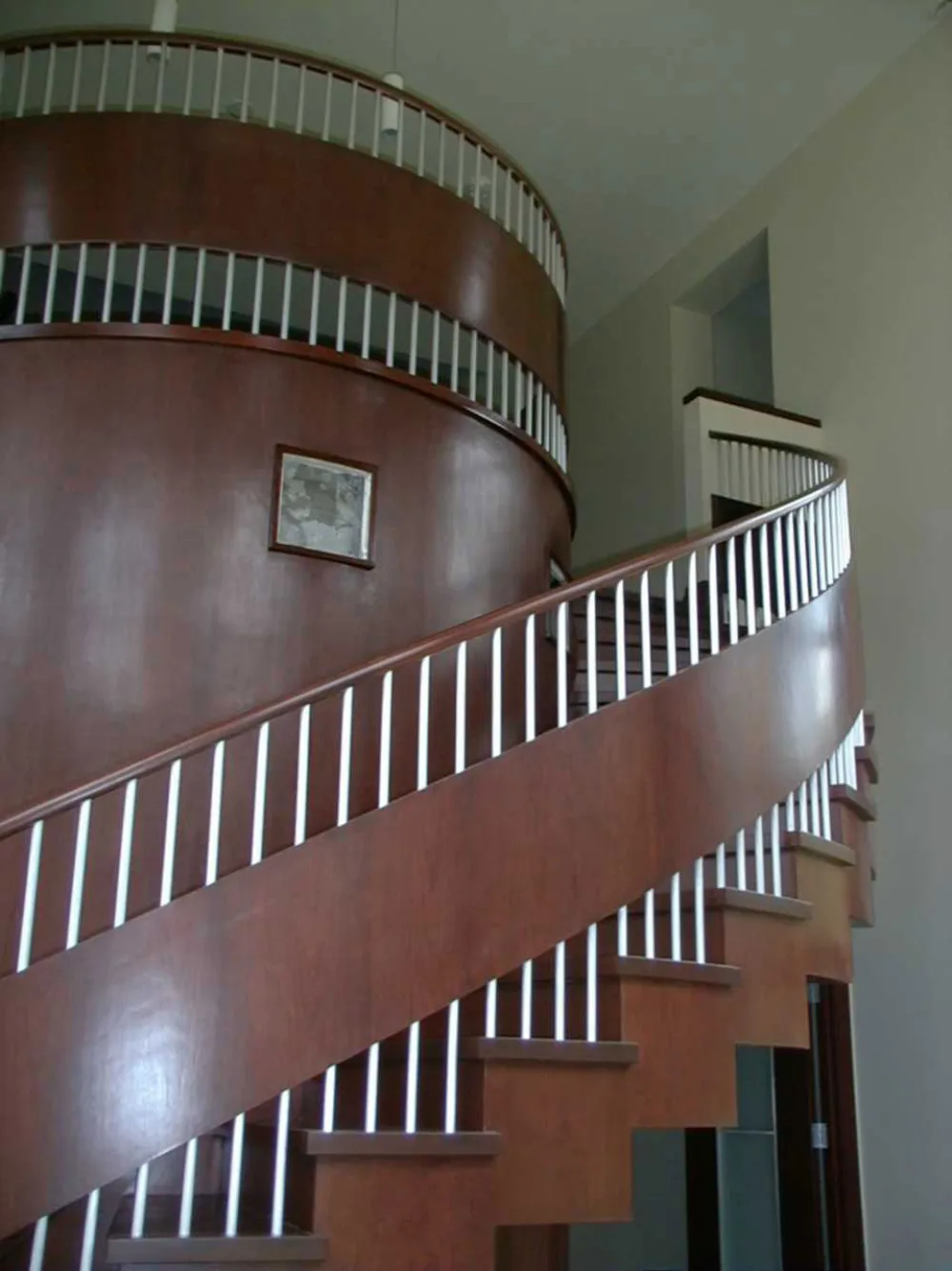 Dark hardwood helical staircase with slender balusters